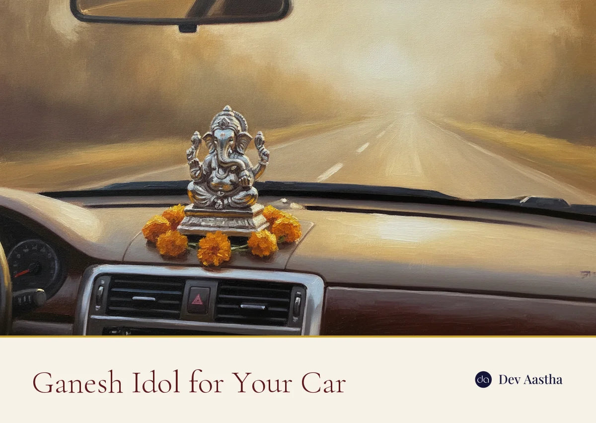 Silver Ganesh idol on a car dashboard with marigolds and the open road ahead