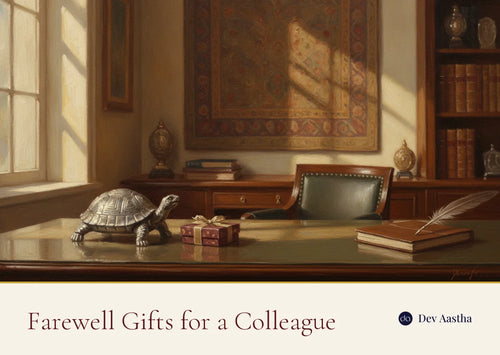 A silver-plated vastu tortoise and a wrapped gift on an office desk, chosen as a farewell gift for a colleague