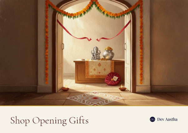 The entrance of a newly opened Indian shop on its first morning, with a marigold garland above the door, a cut red ribbon, a rangoli at the threshold, lit diyas and a silver-plated Ganesha and kalash on the counter