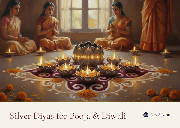Lit silver-plated lotus and flower diyas on a Diwali rangoli with marigold petals