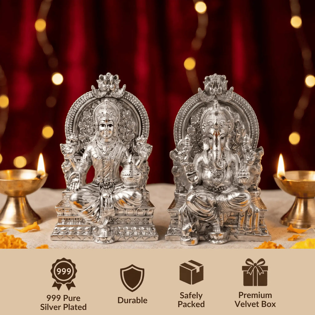 Silver-plated Lakshmi and Ganesh idols on a Diwali puja setup with diyas and marigolds
