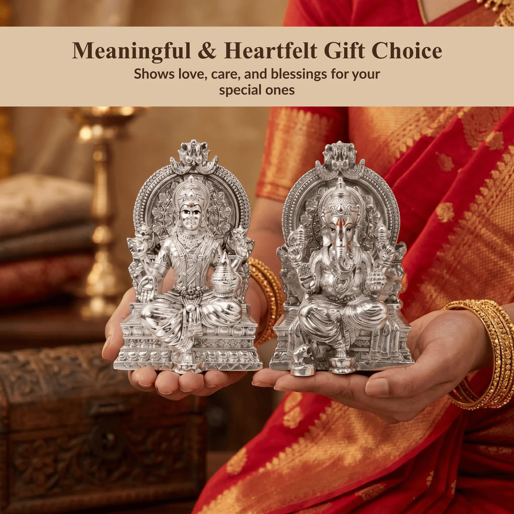 Woman in a red saree holding the Lakshmi Ganesh silver-plated idol set as a gift