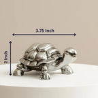 Silver metal turtle figurine measuring 3.75 x 2 inches on white surface