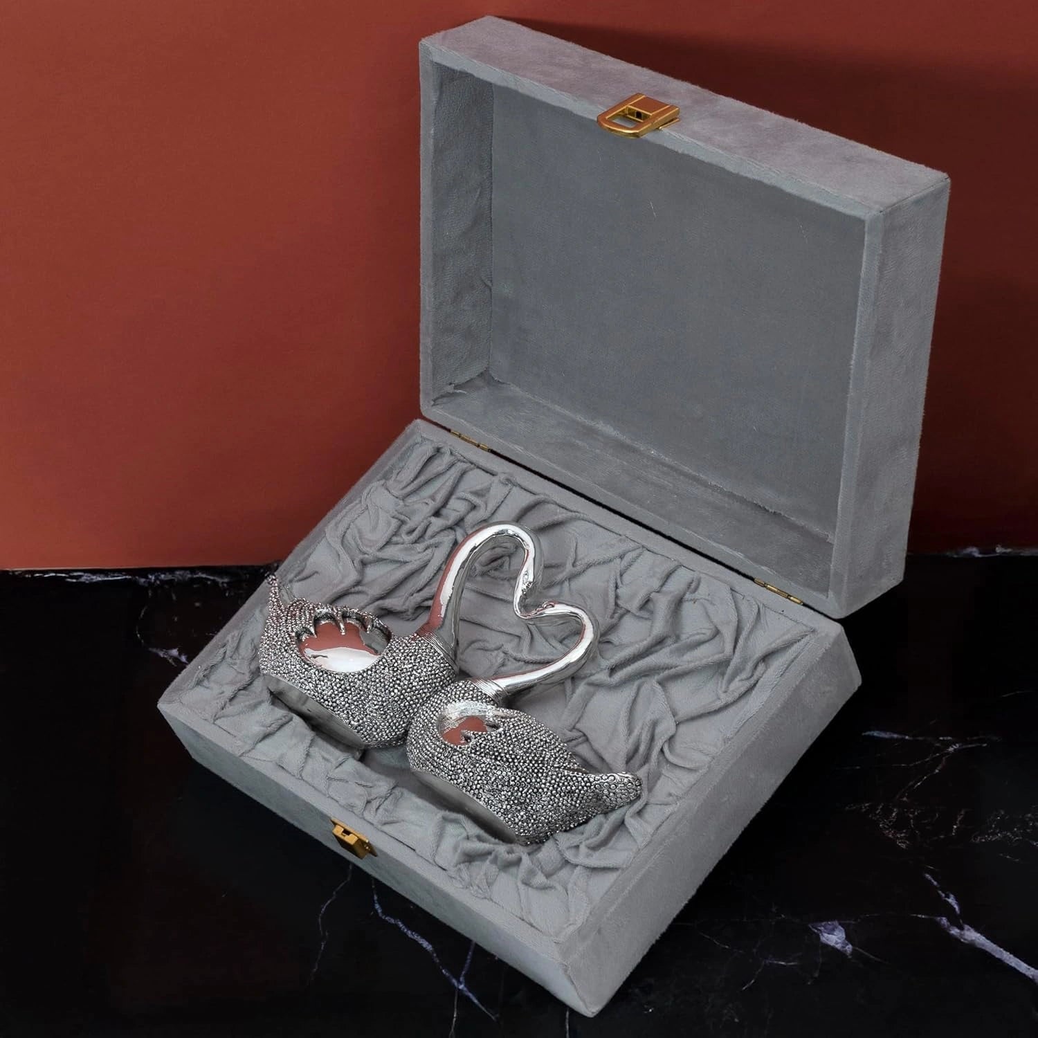 Silver lovebirds showpiece with textured bodies in gray velvet gift box on black surface