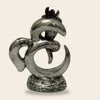 Silver metal abstract bird sculpture with curved shapes on textured base