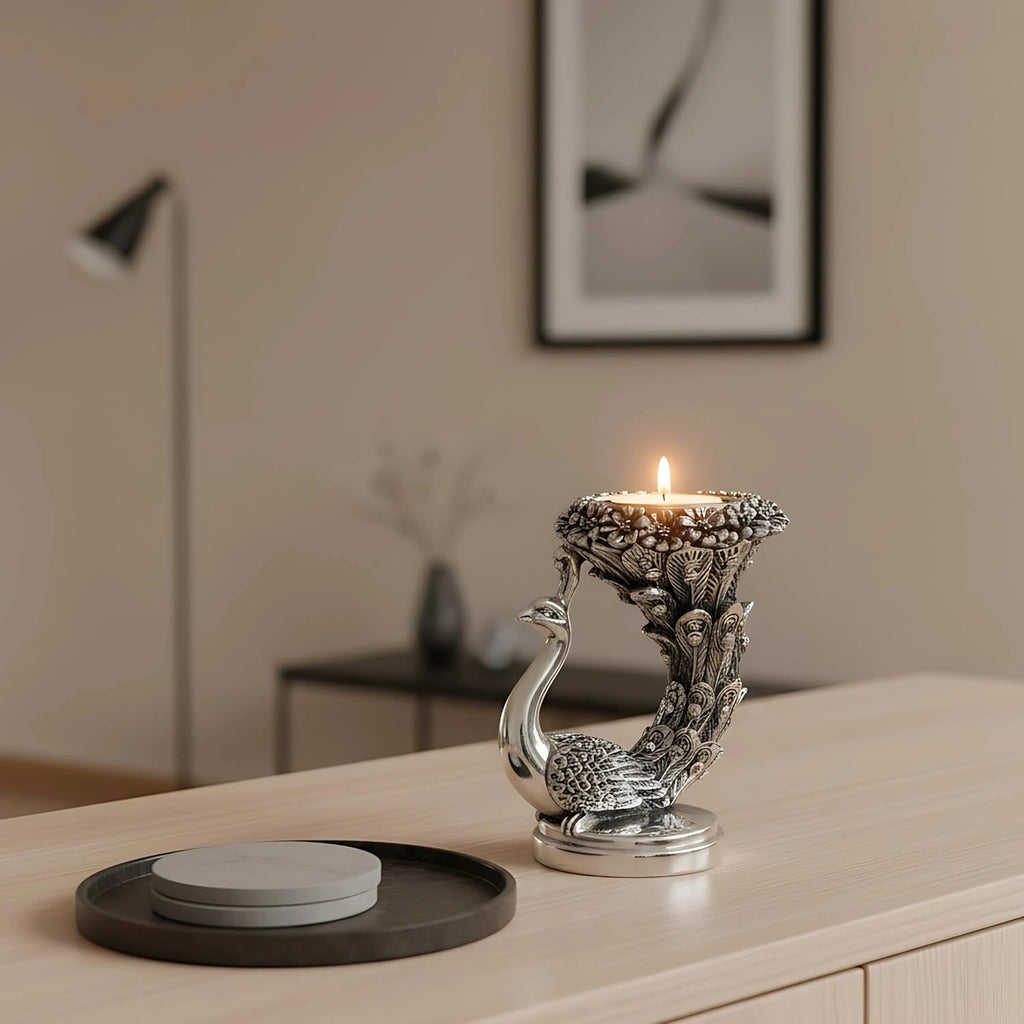 Silver peacock candle holder with lit candle on wooden table in modern living room
