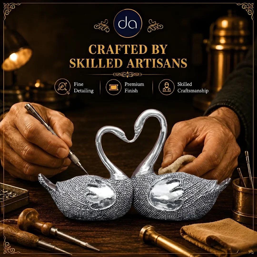 Artisan hands detailing silver-plated swan lovebirds pair with engraving tools