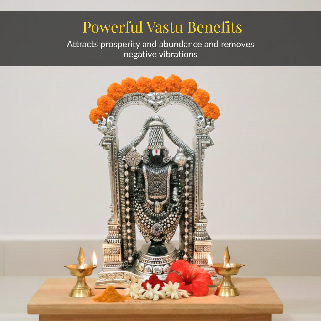 Standing Balaji idol garlanded with marigolds, lit traditional diyas and hibiscus for daily puja