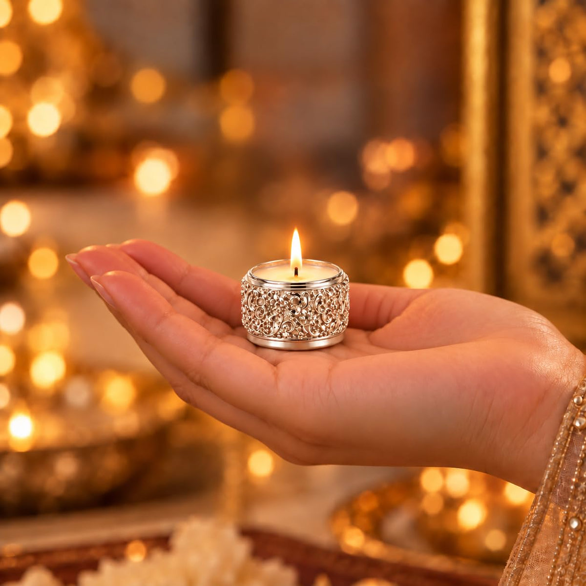 Compact silver-plated tea light holder shown in hand for scale