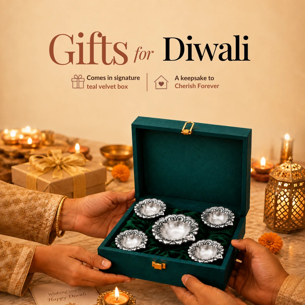 Hands presenting a teal velvet box of five silver flower diyas amid Diwali lamps and marigolds #set-of-5