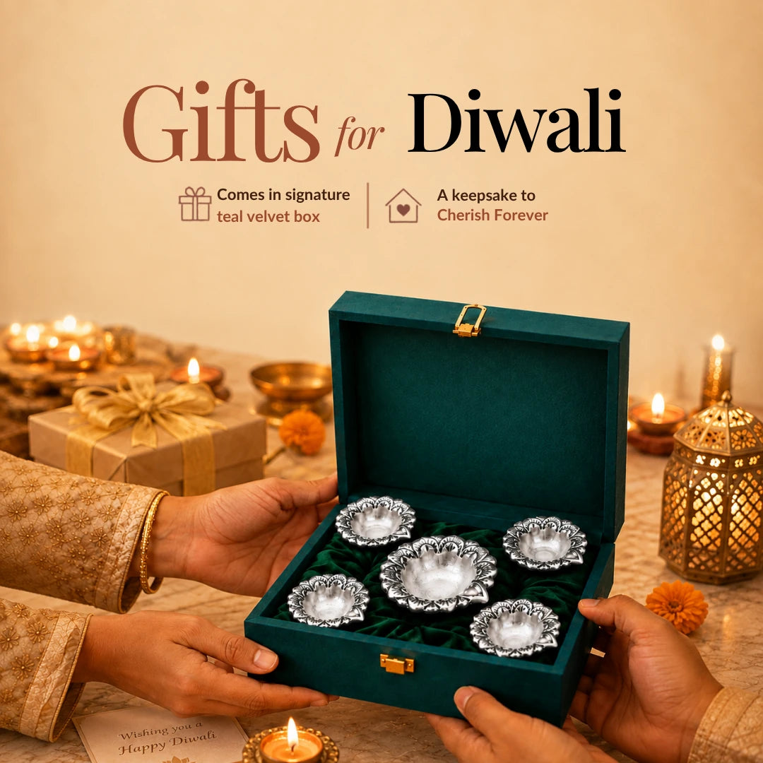 Hands presenting a teal velvet box of five silver flower diyas amid Diwali lamps and marigolds #set-of-5