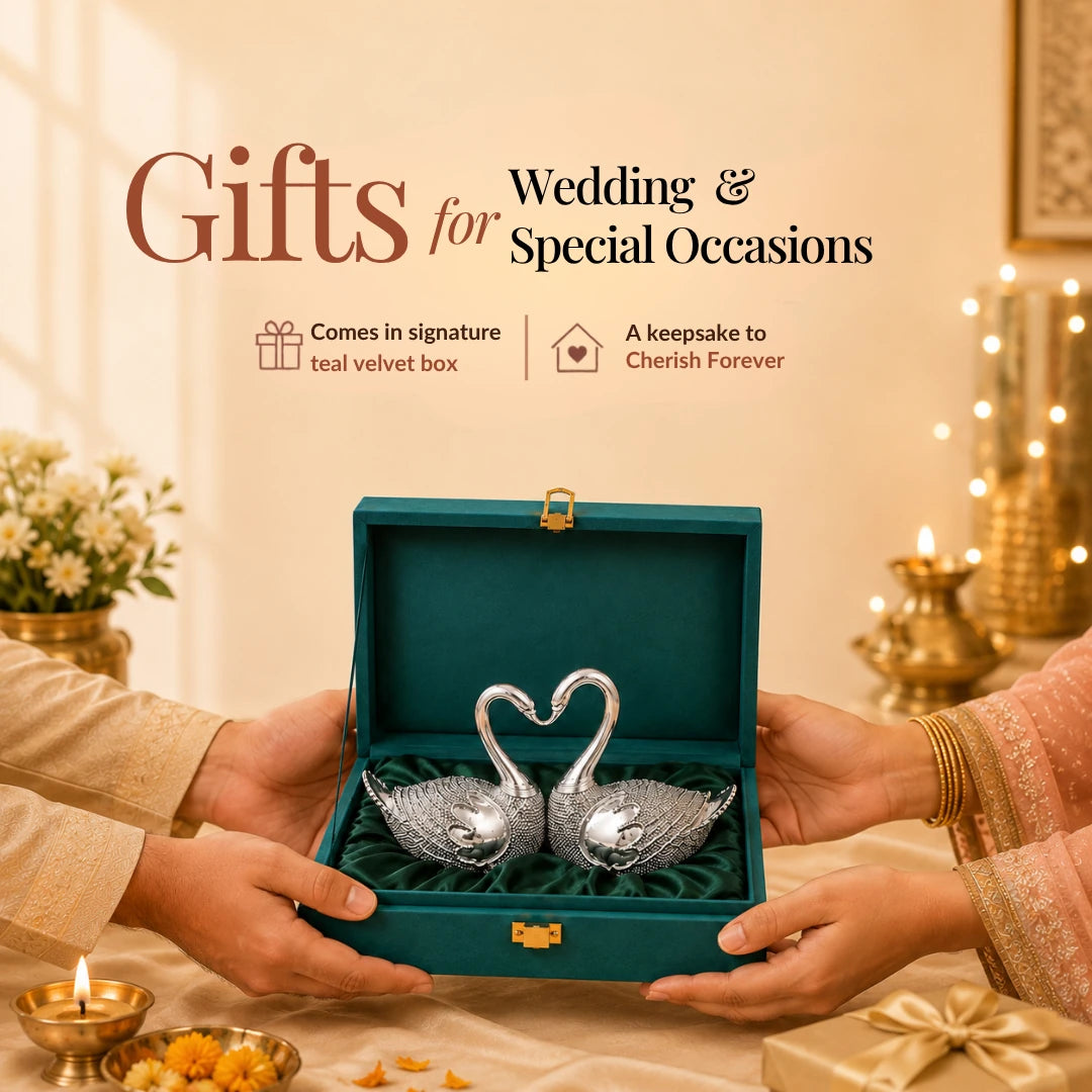 Hands presenting the silver swan pair in its signature teal velvet gift box amid festive lamps #5-inch