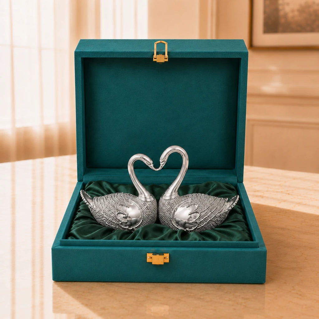 Silver-plated swan pair with necks curved into a heart, on green satin inside an open teal velvet gift box #5-inch