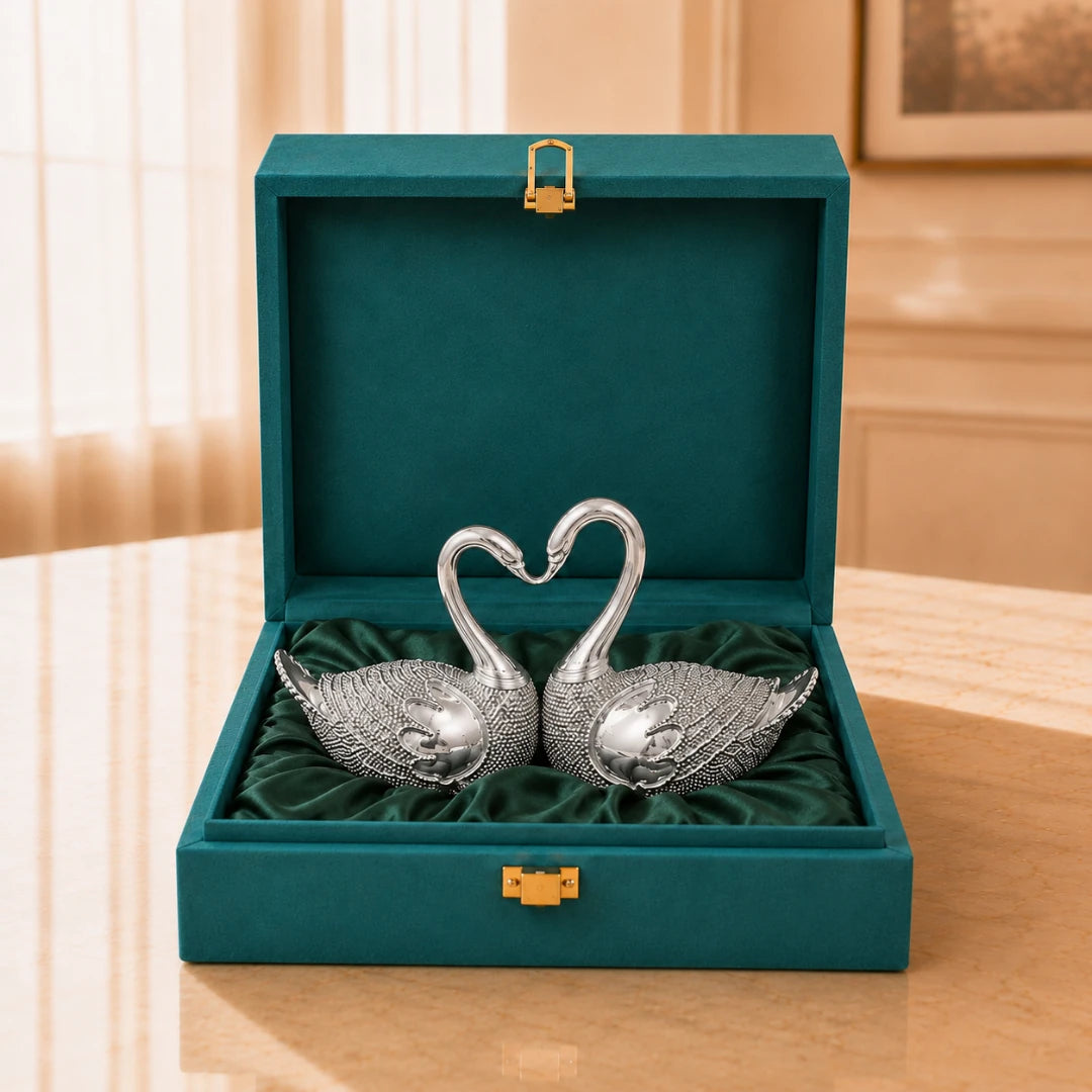 Silver-plated swan pair with necks curved into a heart, on green satin inside an open teal velvet gift box #5-inch